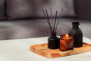 Aromatic reed freshener and candle on table in room photo