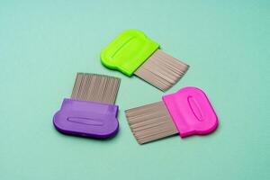 Three combs for lice removing on green background photo