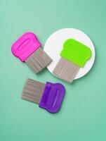 Three combs for lice removing on green background photo