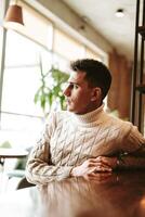 Man Sitting at a Table With Arms Crossed photo
