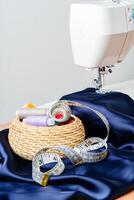 Sewing tools and materials arranged on fabric with a sewing machine in a bright workspace photo