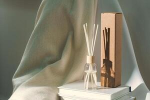 Liquid home perfume in glass diffuser with sticks on chair photo
