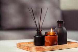 Aromatic reed freshener and candle on table in room photo