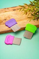 Three combs for lice removing on green background photo