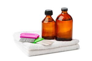Comb, anti lice medicine and towel on white background photo
