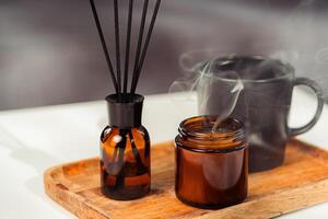 Aromatic reed freshener and candle on table in room photo