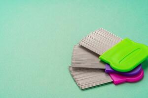 Three combs for lice removing on green background photo