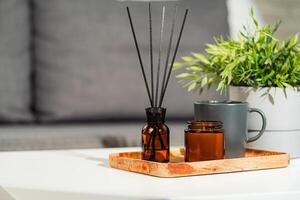 Aromatic reed freshener and candle on table in room photo