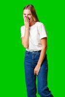 Smiling Young Woman in Casual Outfit Posing Against Green Background photo