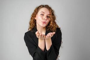 Young Woman Blowing a Kiss Towards the Camera in a Studio Setting photo