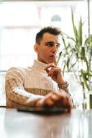 Man Sitting at Table With Hands Raised photo