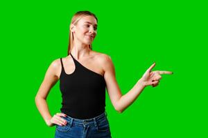 Young Woman Pointing at Something against green background photo
