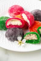 Multi-colored Japanese cakes Mochi in a white plate photo