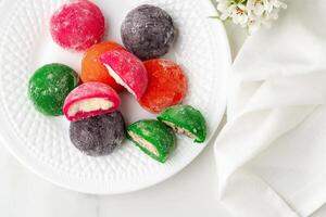 Multi-colored Japanese cakes Mochi in a white plate photo