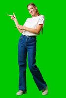 Young Woman Pointing at Something against green background photo