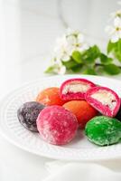 Multi-colored Japanese cakes Mochi in a white plate photo