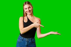 Young Woman Pointing at Something against green background photo