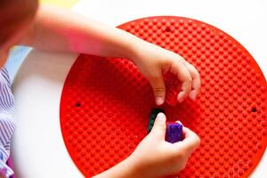 Child Engaged in Creative Play With Colorful Building Blocks on a Round Base photo