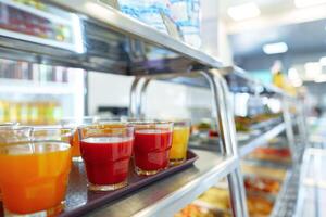 Colorful Array of Fruit Juice Cups on a Serving Cart in a Cafeteria photo