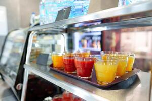 Colorful Array of Fruit Juice Cups on a Serving Cart in a Cafeteria photo