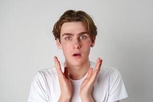 Young Man With Surprised Expression and Hands Raised in Studio Setting photo