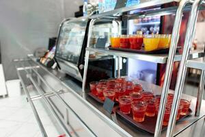 Colorful Array of Fruit Juice Cups on a Serving Cart in a Cafeteria photo