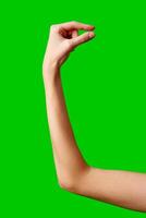 A womans hand extends upward into the air, fingers outstretched, reaching upward towards an unseen destination. photo