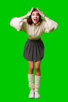joven mujer gesticulando emoción en casual atuendo en contra verde pantalla fondo foto