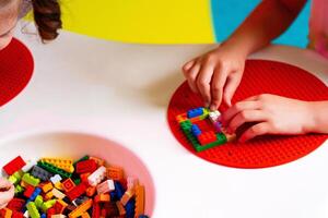 Child Engaged in Creative Play With Colorful Building Blocks on a Round Base photo
