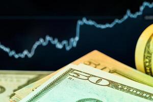 Dollars in front of a monitor with a price chart. Forex and trading. photo