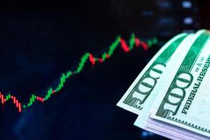 Dollars in front of a monitor with a price chart. Forex and trading. photo