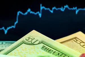 Dollars in front of a monitor with a price chart. Forex and trading. photo