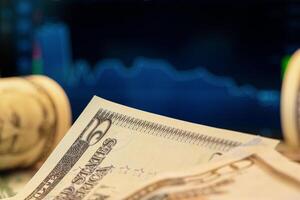 Dollars in front of a monitor with a price chart. Forex and trading. photo