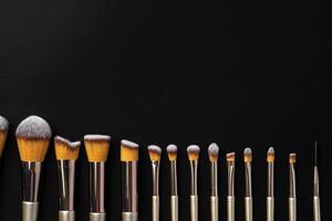 Collection of make up brushes on black background photo