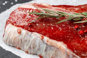 Raw fresh meat t-bone steak with spices on a dark background photo