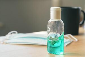 Working place table with small bottle of antibacterial sanitizer photo