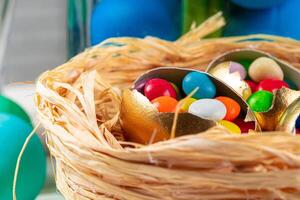 Egg shell with colorful candies inside in a decorative Easter nest photo