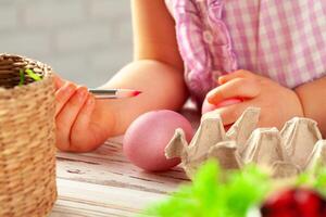 Cropped image of a little girl painting eggs for Easter photo