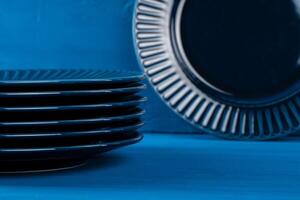 Dark blue crockery on blue wooden background photo