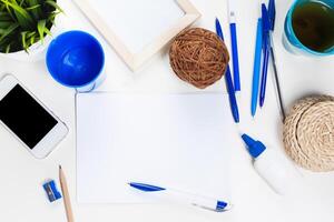 White office desk table with a lot of things on it. Top view photo