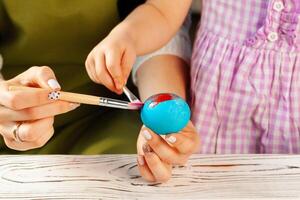 Mother and daughter coloring eggs for Easter photo