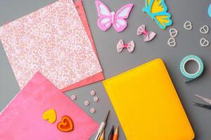 Crafting supplies arranged for a DIY project on a gray table with scissors, washi tape, and decorative items photo