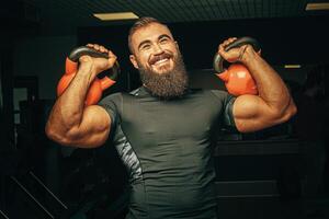 Bodybuilder doing exercises with dumbbells in a dark gym photo