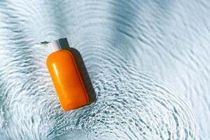 Tropical setting with a skincare tube resting on textured white surface illuminated by sunlight photo