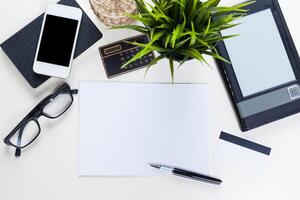 White office desk table with a lot of things on it. Top view photo