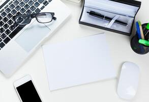 White office desk table with a lot of things on it. Top view photo