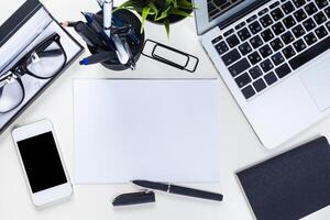 White office desk table with a lot of things on it. Top view photo