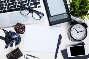 White office desk table with a lot of things on it. Top view photo