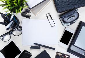 White office desk table with a lot of things on it. Top view photo