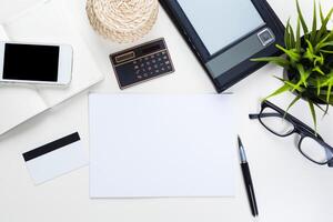 White office desk table with a lot of things on it. Top view photo